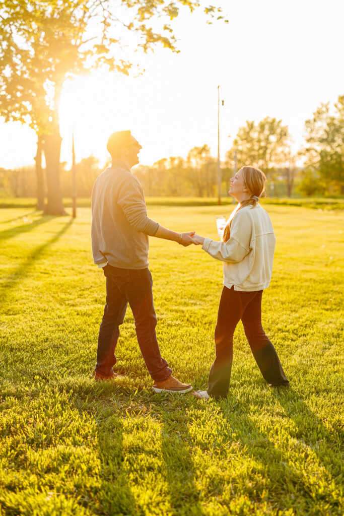 Couple walking hand in hand across the lawn at sunset, warm golden light at The Wells Estate.